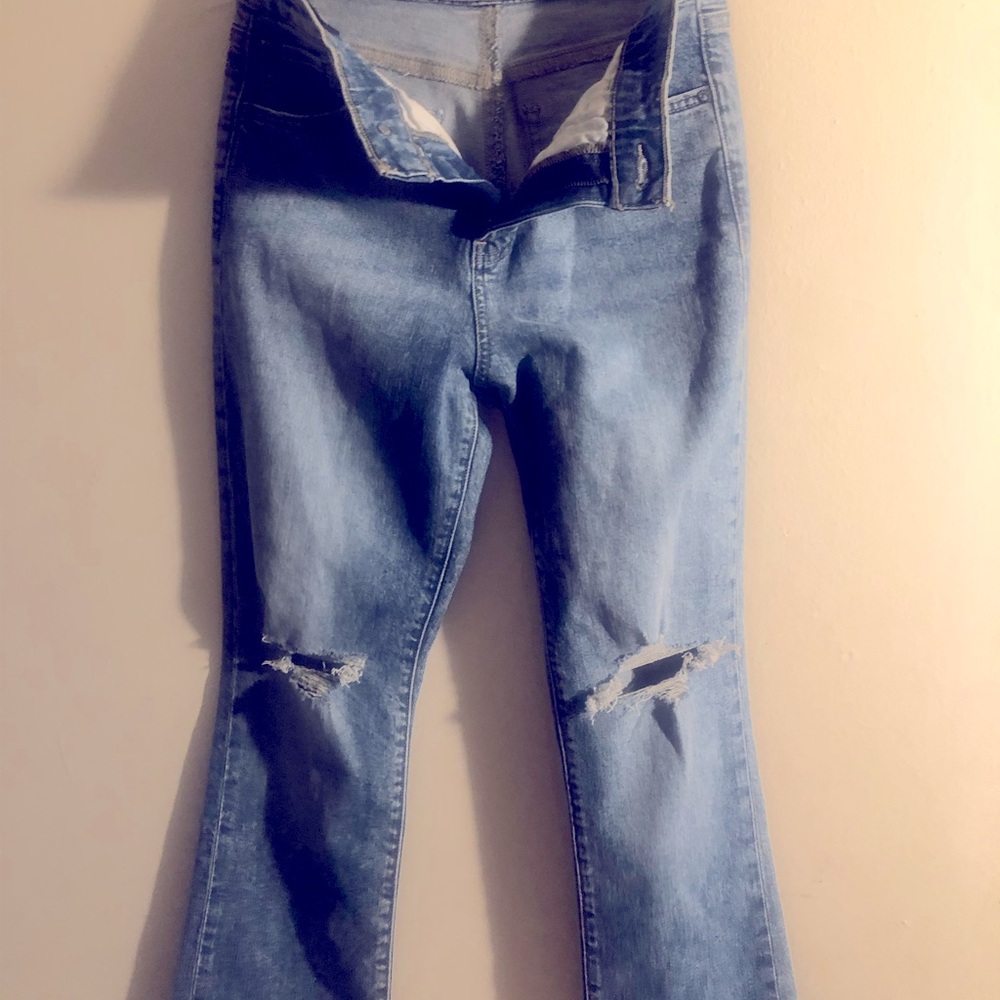 Express jeans, light blue in color, styled with rips at knees, waist 26.